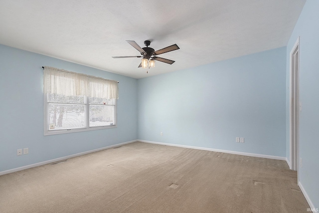 spare room with light colored carpet and ceiling fan