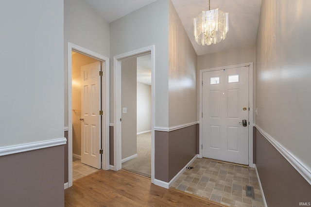 foyer with light wood-type flooring and a notable chandelier