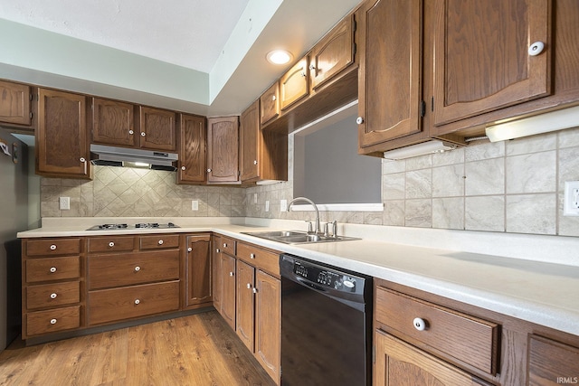 kitchen with white gas cooktop, sink, black dishwasher, light hardwood / wood-style flooring, and tasteful backsplash