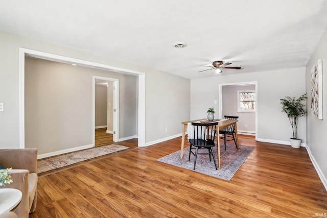 dining space with ceiling fan and hardwood / wood-style floors