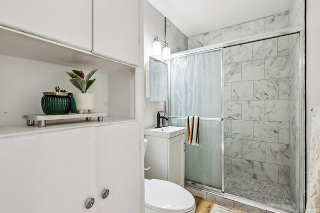 bathroom featuring toilet, hardwood / wood-style flooring, an enclosed shower, and vanity