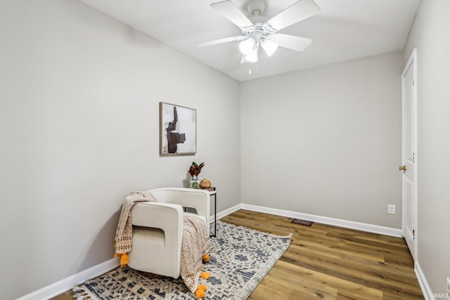 living area with hardwood / wood-style floors and ceiling fan