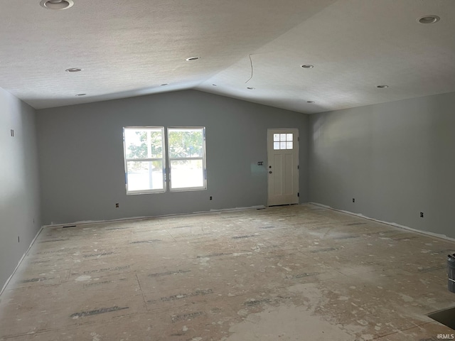 interior space featuring a textured ceiling and vaulted ceiling