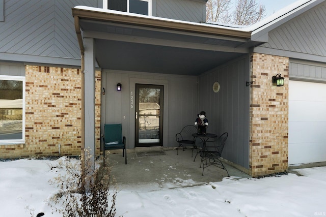 snow covered property entrance featuring covered porch