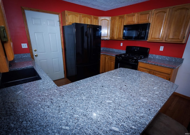 kitchen featuring sink, a textured ceiling, and black appliances