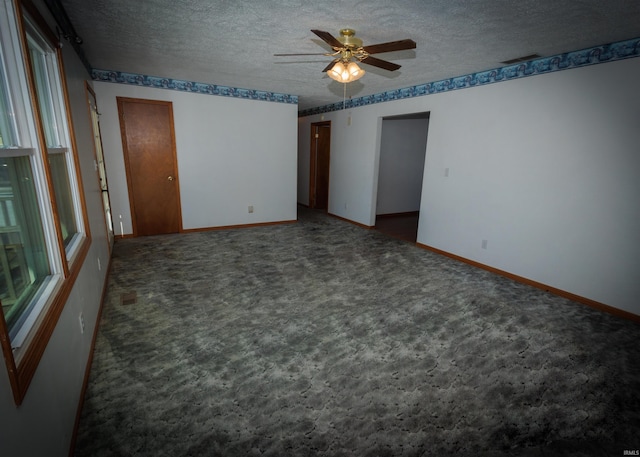 carpeted empty room with ceiling fan and a textured ceiling