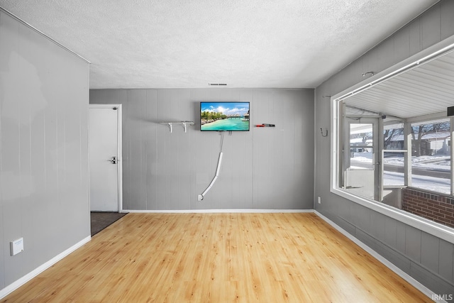 empty room featuring a textured ceiling and hardwood / wood-style floors