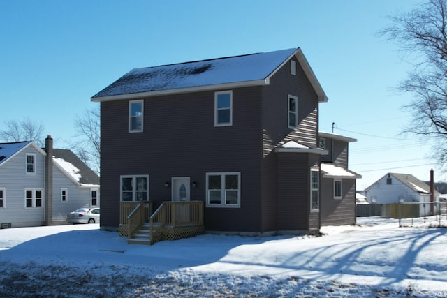 view of snow covered back of property