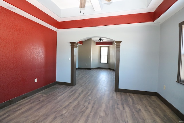 unfurnished room with dark wood-type flooring, ceiling fan, and decorative columns