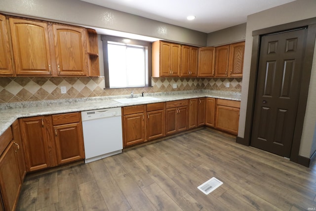 kitchen featuring dishwasher, light stone countertops, sink, and dark hardwood / wood-style flooring