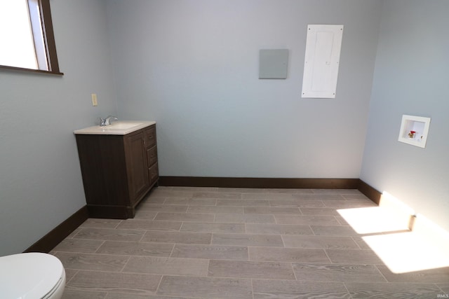 bathroom with vanity, toilet, and electric panel