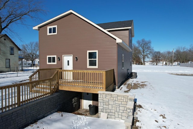 snow covered property with a deck