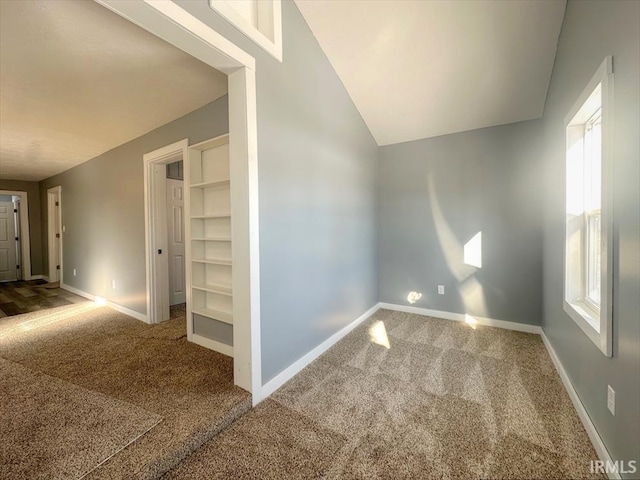 interior space featuring carpet, lofted ceiling, and a healthy amount of sunlight