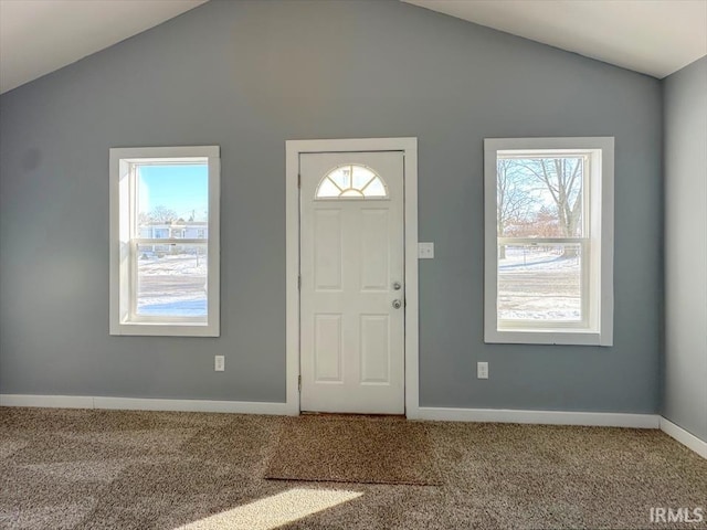 carpeted foyer featuring vaulted ceiling