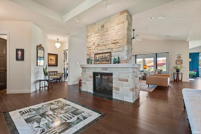 living room with vaulted ceiling, ceiling fan, dark hardwood / wood-style flooring, and a stone fireplace