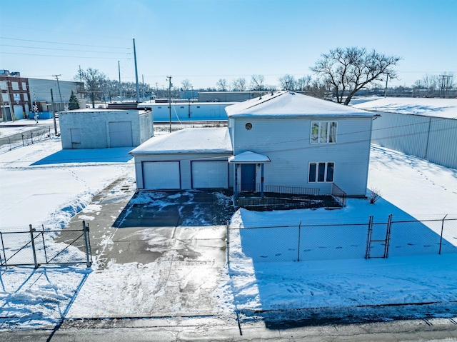 snow covered house featuring a garage