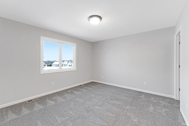 spare room featuring a textured ceiling and carpet flooring