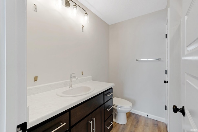 bathroom featuring hardwood / wood-style floors, vanity, and toilet