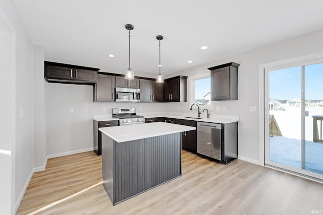 kitchen featuring a center island, light wood-type flooring, a healthy amount of sunlight, and appliances with stainless steel finishes