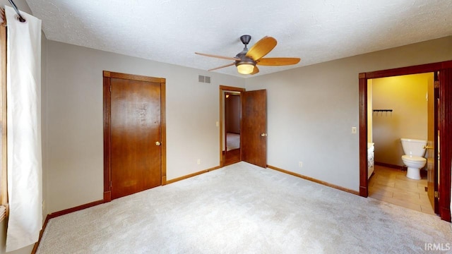 unfurnished bedroom with ensuite bath, a textured ceiling, ceiling fan, and light carpet