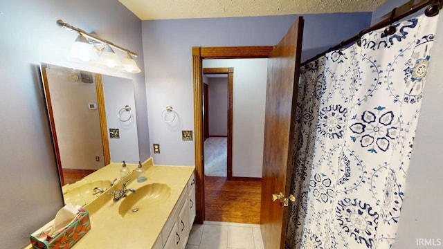 bathroom featuring a shower with curtain, tile patterned flooring, a textured ceiling, and vanity