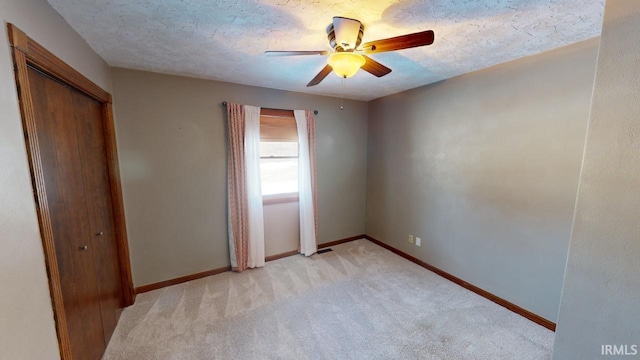 interior space featuring light colored carpet, ceiling fan, and a textured ceiling