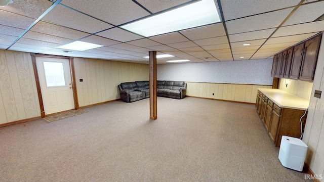 basement with light colored carpet and a paneled ceiling