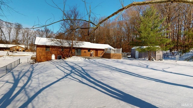 yard covered in snow featuring a storage shed