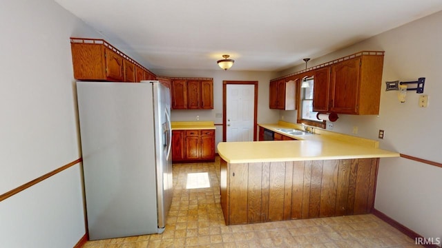 kitchen with stainless steel refrigerator with ice dispenser, sink, and kitchen peninsula