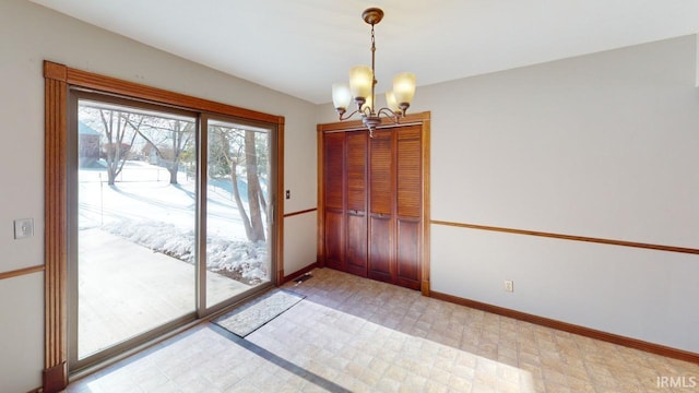 doorway to outside featuring an inviting chandelier