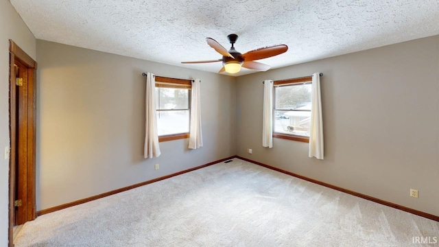 empty room featuring a textured ceiling, ceiling fan, and carpet flooring