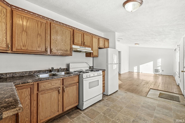 kitchen featuring sink, white appliances, and a textured ceiling