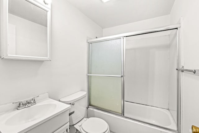 full bathroom featuring vanity, combined bath / shower with glass door, and toilet