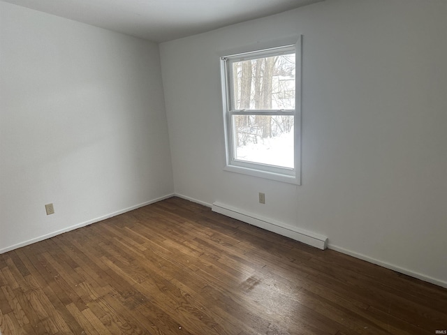 spare room with dark hardwood / wood-style floors and baseboard heating