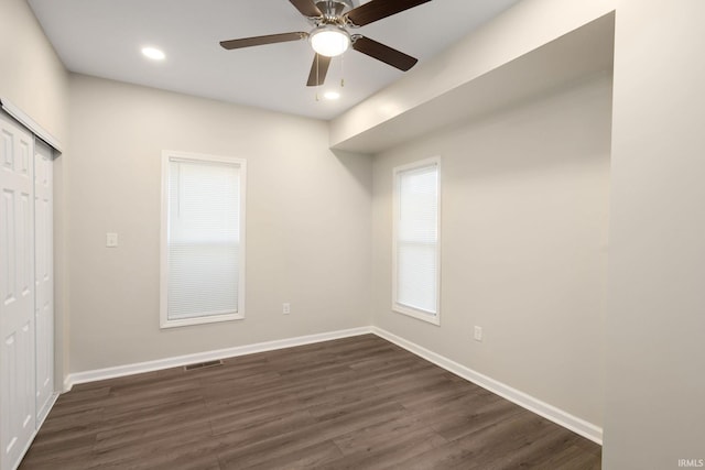 spare room featuring dark wood-type flooring and ceiling fan