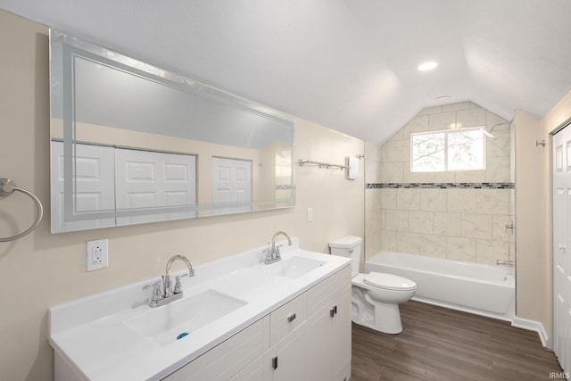 full bathroom with toilet, lofted ceiling, tiled shower / bath combo, wood-type flooring, and vanity