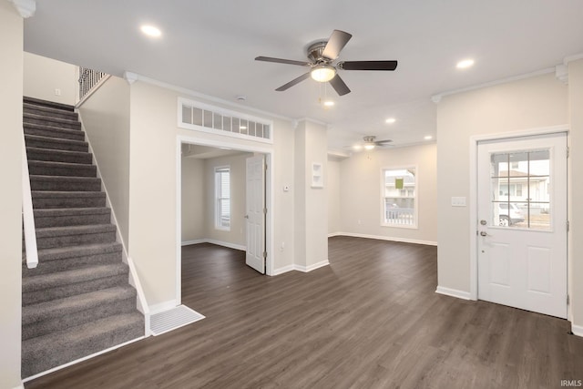 entrance foyer with ceiling fan, plenty of natural light, crown molding, and dark wood-type flooring