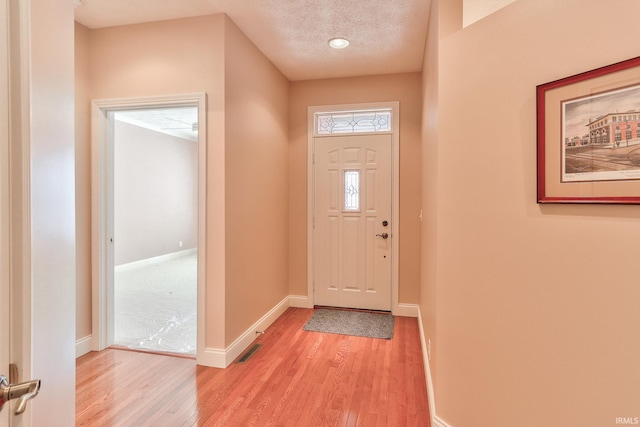 entrance foyer with a textured ceiling and light wood-type flooring