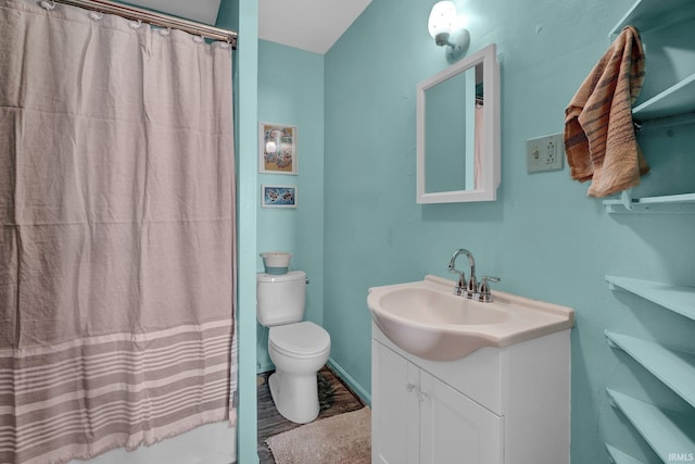 bathroom with toilet, curtained shower, wood-type flooring, and vanity