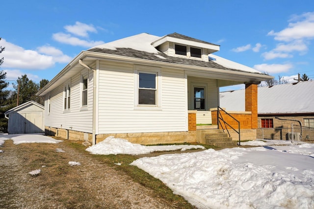 view of front of home with covered porch and a shed