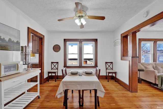 dining room featuring a textured ceiling, ceiling fan, light hardwood / wood-style flooring, and plenty of natural light