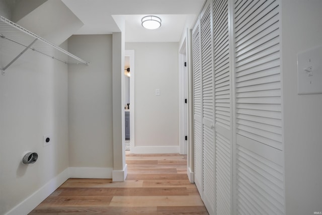 clothes washing area with light wood-type flooring and hookup for an electric dryer