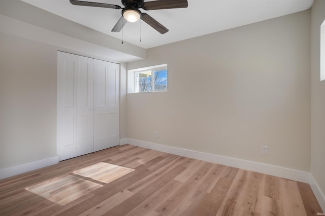 unfurnished bedroom with ceiling fan, light wood-type flooring, and a closet