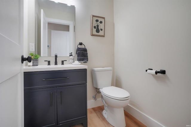 bathroom featuring toilet, wood-type flooring, and vanity