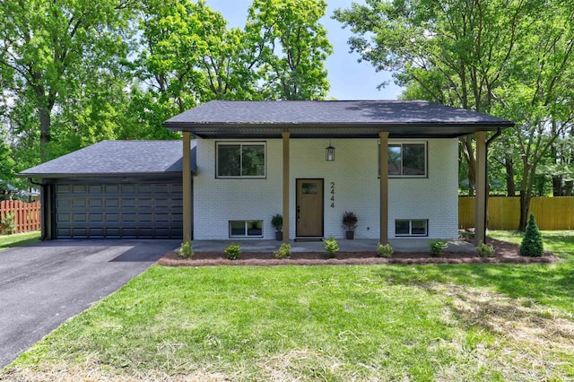 2444 Clover Cir, Newburgh, IN 47630 - raised ranch with brick siding, an attached garage, driveway, and roof with shingles