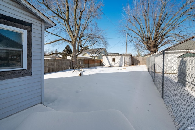 yard layered in snow with a storage shed