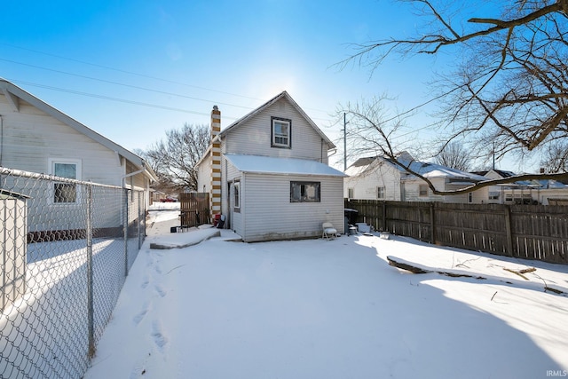 view of snow covered back of property