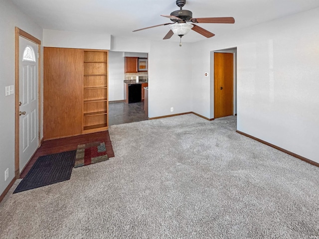 interior space with ceiling fan and dark colored carpet