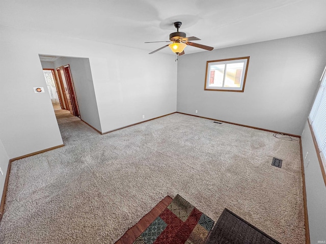 spare room with ceiling fan and carpet