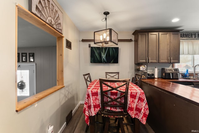 dining room with an inviting chandelier and dark hardwood / wood-style floors